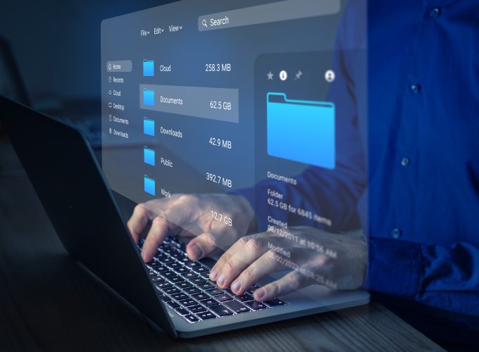File manager used to browse folders on computer. Exploring directories on hard drive. Document management system (DMS). Business data and process. Person working on laptop.